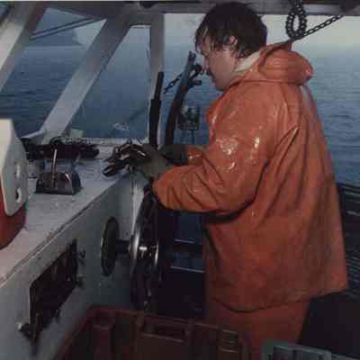 A photo view of a lobsterman fishing in the rain.