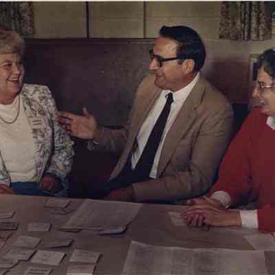 A photo view of three people at a table. 9/23/1988.