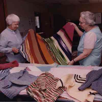 A photo view of 2 women looking at material. 5/26/1989.