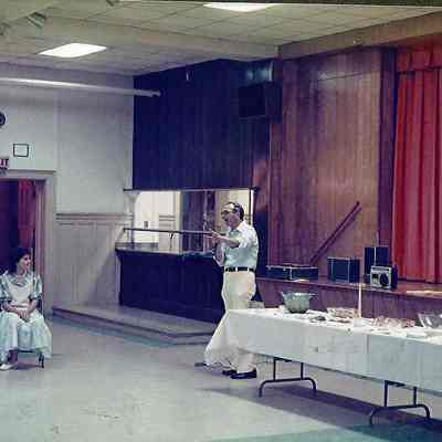 A color photograph of Gene Gagne calling the Miss Brunswick contestants to come and introduce themselves.