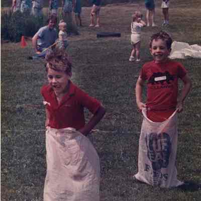 A photo view of two boys in a potato sack race. 6/20/1988.