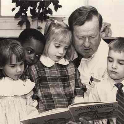 A photo view of a teacher reading to children. 11/6/1992.