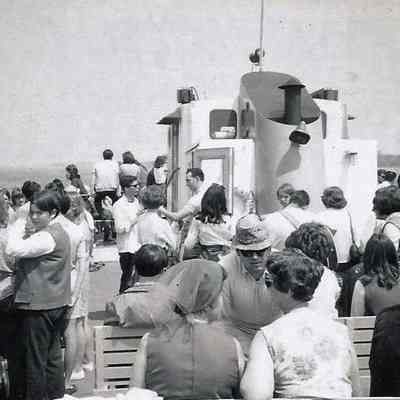 A B/W photograph of a large number of people aboard a boat.