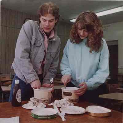 A photo view of 2 youngsters dishing out ice cream. 3/16/1988.