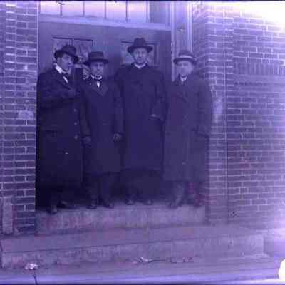 Four men in top coats.