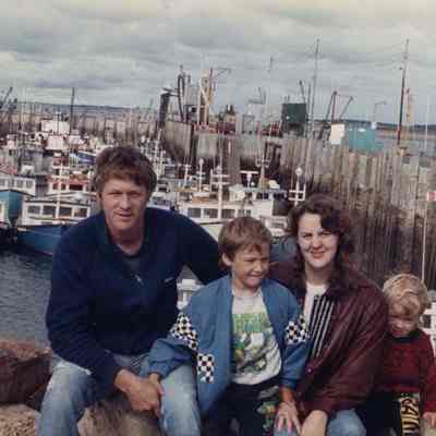 A photo view of a family sitting by the ocean. 10/11/1990.