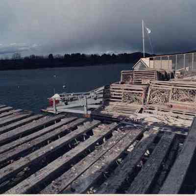 A photo view of a dock with lots of lobster traps. 12/11/1990.
