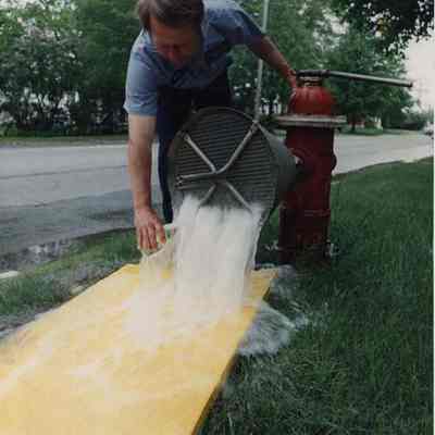 A photo view of a man getting a water sample. 6/13/1989.