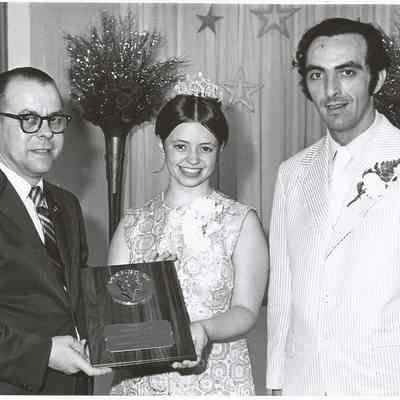 Sharon Hinckley is presenting the pageant award to Dick Tomko for his many years of service to the pageant while Gene Gagne is looking on.