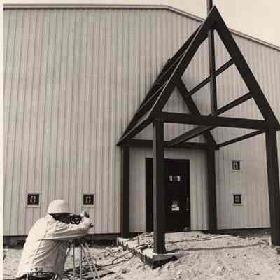 A photo view of a land surveyor in front of a church. 10/9/1992.