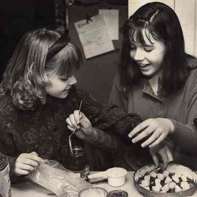 A photo view of two girls cooking. 3/30/1992.