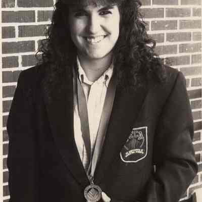 A photo view of a woman holding a medal. 6/2/1992.