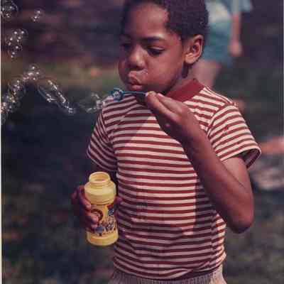 A photo view of a boy blowing bubbles. 6/22/1988.