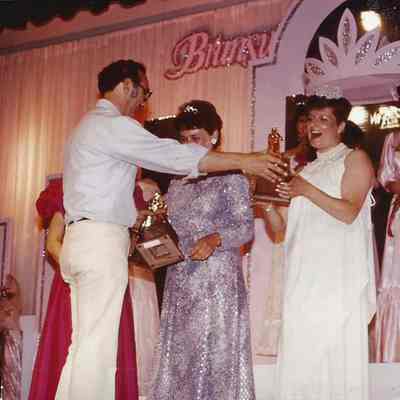 A color photograph of Gene Gagne the pageant director presenting trophies.