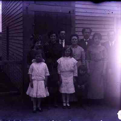 Eleven people posing in front of a house.
