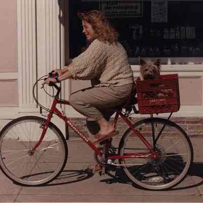 A photo view of a lady on a bicycle. 7/14/1989.