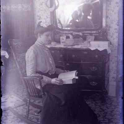 A negative of a woman sitting.