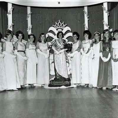 A B/W photograph of 13 girls wearing gowns.