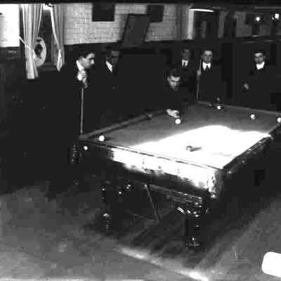 Six men playing pool.