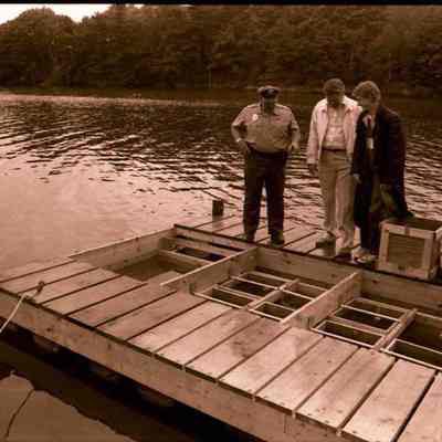 A photo view of three people examining a newly built float.