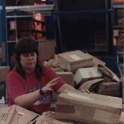 A photo view of a woman amongst a lot of packages. 8/17/1989.