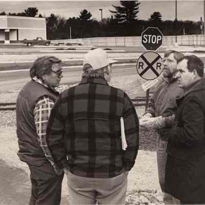 A photo view of four men discussing traffic flow.