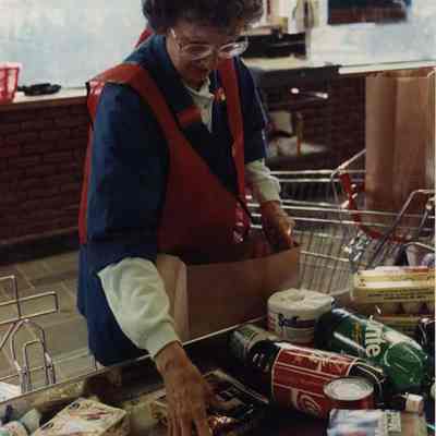 A photo view of Mary Moise bagging groceries. 1/2/1990.