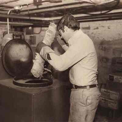 A photo view of Christopher Livesay putting wood in his furnace, 1/19/1981.