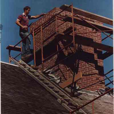 A photo view of a mason working on a chimney. 9/3/1987.