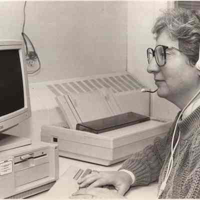 A photo view of a woman in front of a computer. 11/3/1992.