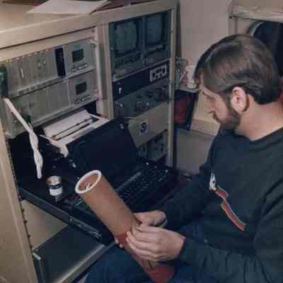 A photo view of a man working at a computer. 12/13/1988.
