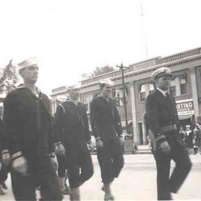 A photo view of marching Navy men.