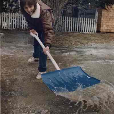 A photo view of a woman trying to shovel water.