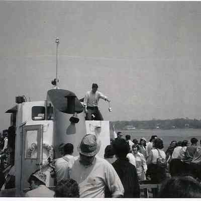 A B/W photograph of a large number of people on a boat.