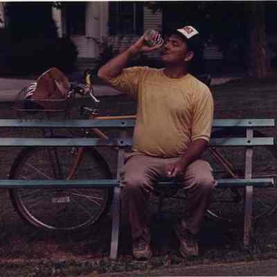 A photo view of a man taking a break on a park bench. 8/16/1988.