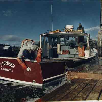 A photo view of 3 men cleaning their boat. 11/23/1988.