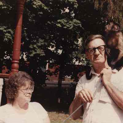 A photo view of two people and a monkey. 8/2/1989.