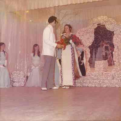 Gene presenting the roses to Althea while Agnes is getting the cape ready.
