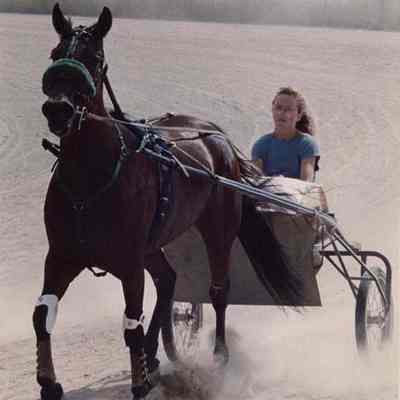 A photo view of a girl driving a race horse. 7/15/1988.