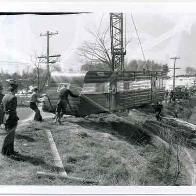 A house trailer being lifted out of a ditch