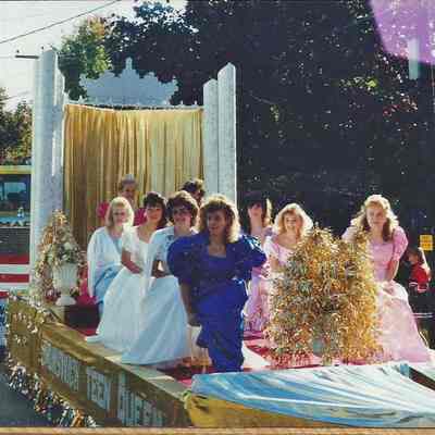 A color photograph of the Teen Queen float with the girls sitting on the float.