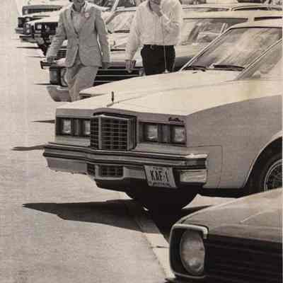 A photo view of Sherry Huber as she looks at cars. 4/26/1982.