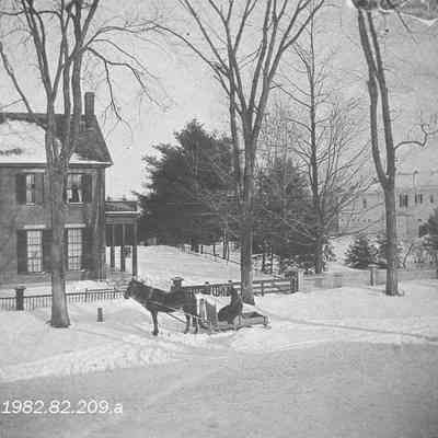 A photo of a man in a horse drawn sleigh.