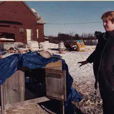 A photo view of a lady showing an animal cage. 12/13/1989.