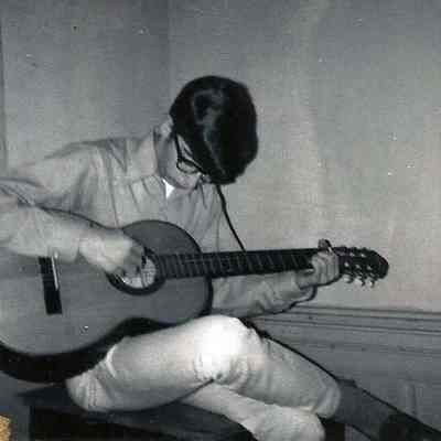 A B/W Polaroid photograph of a young man playing a guitar