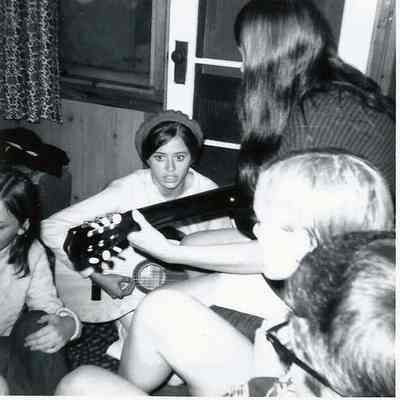 A B/W photograph of some young people singing.