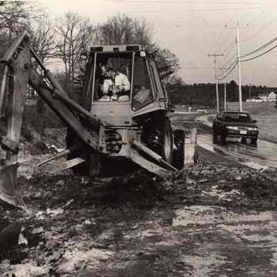 A photo view of Mike Weber operating a backhoe. 1/28/1992.