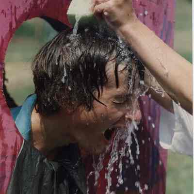 A photo view of boy getting dosed with water. 7/28/1989