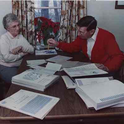A photo view of a man helping a woman with her income tax. 3/11/1988.