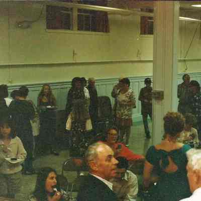 A color photograph of people talking and eating